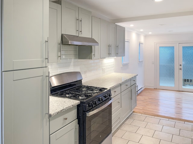 kitchen featuring french doors, backsplash, light hardwood / wood-style floors, light stone counters, and stainless steel gas range