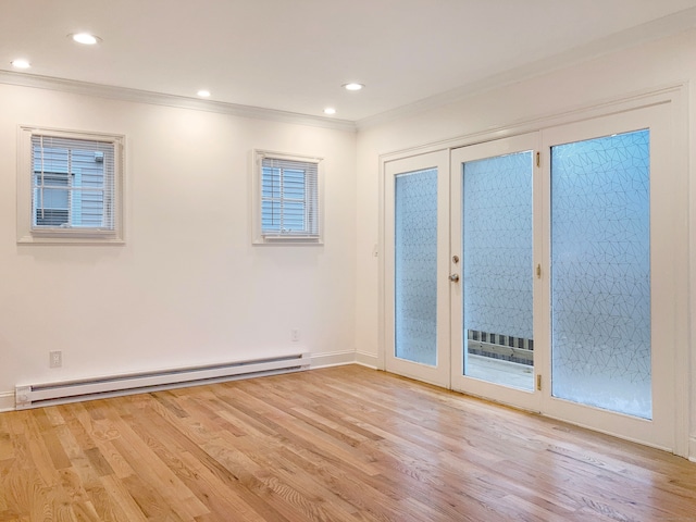 empty room with crown molding, baseboard heating, light wood-type flooring, and a wealth of natural light