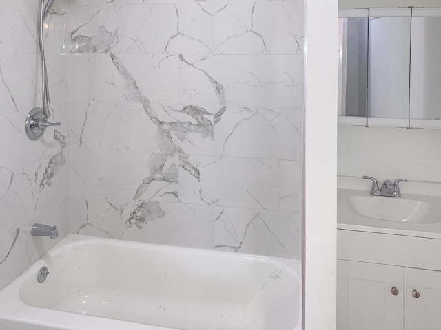 bathroom featuring vanity and tiled shower / bath