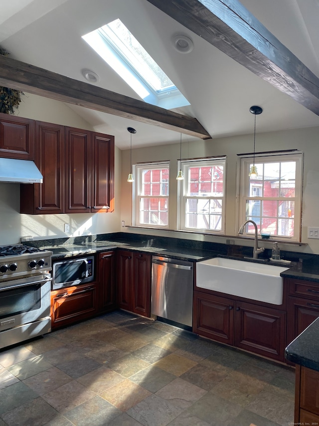 kitchen featuring hanging light fixtures, sink, stainless steel appliances, and vaulted ceiling with skylight