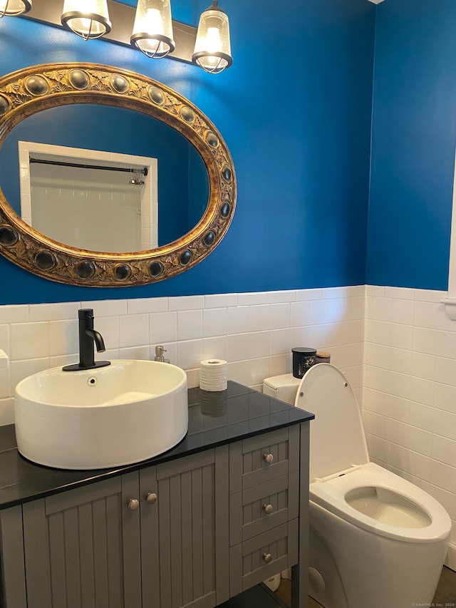 bathroom featuring vanity, toilet, and tile walls