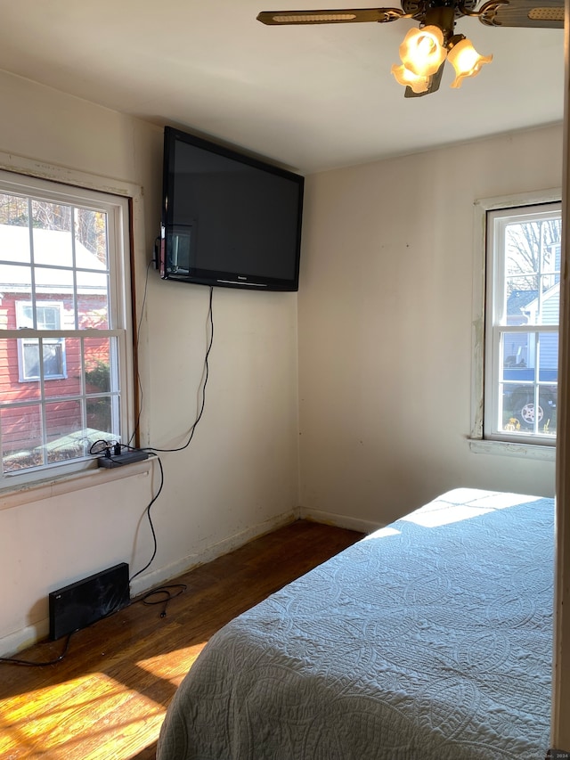 bedroom featuring multiple windows, ceiling fan, and hardwood / wood-style flooring