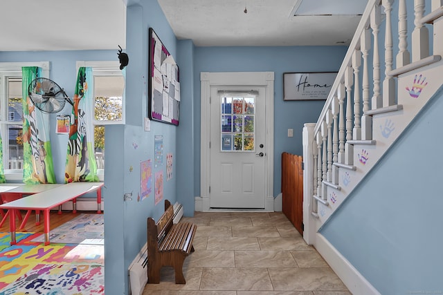 doorway to outside featuring baseboard heating and light tile patterned flooring