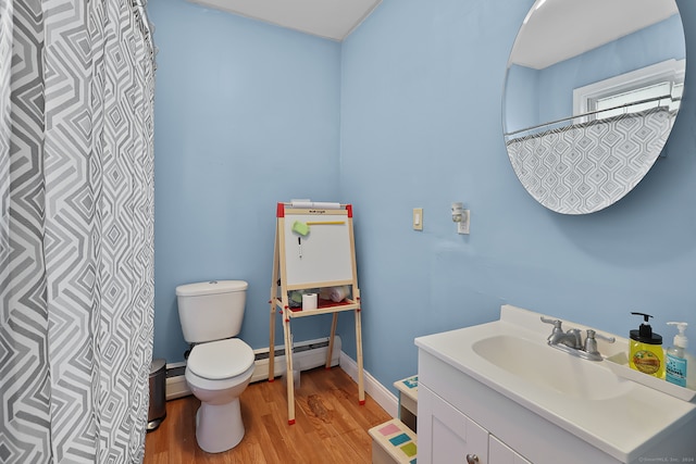 bathroom with vanity, toilet, hardwood / wood-style flooring, and baseboard heating