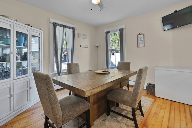 dining space with light hardwood / wood-style floors and ceiling fan