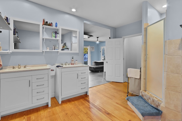 bathroom featuring vanity, hardwood / wood-style floors, and a shower with shower door