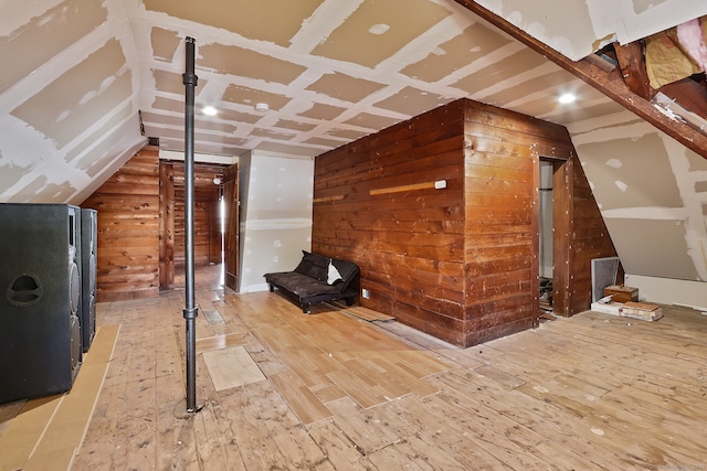 bonus room featuring light hardwood / wood-style floors and wooden walls