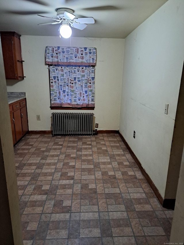 unfurnished dining area with radiator and ceiling fan