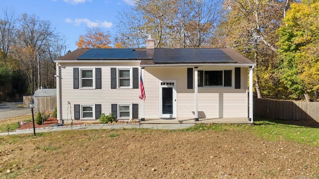 bi-level home featuring solar panels and a front yard