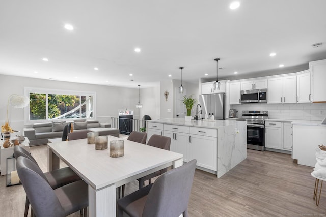 dining space with sink and light wood-type flooring