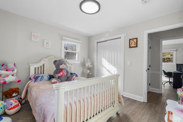 bedroom with multiple windows and dark hardwood / wood-style flooring