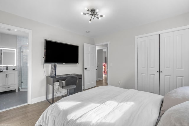 bedroom featuring connected bathroom, a closet, a chandelier, and dark hardwood / wood-style floors