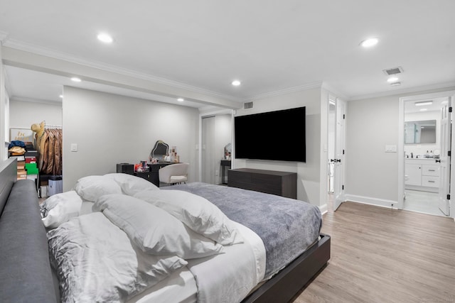 bedroom with a closet, ensuite bathroom, ornamental molding, and light hardwood / wood-style flooring