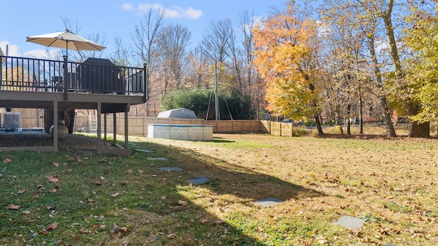 view of yard with cooling unit and a pool side deck