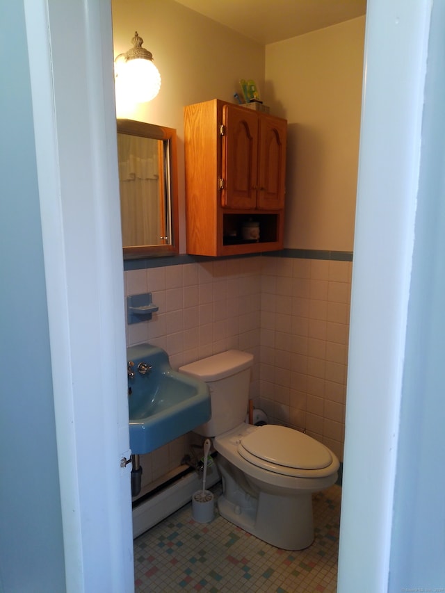 bathroom featuring a baseboard radiator, sink, toilet, tile walls, and tile patterned flooring