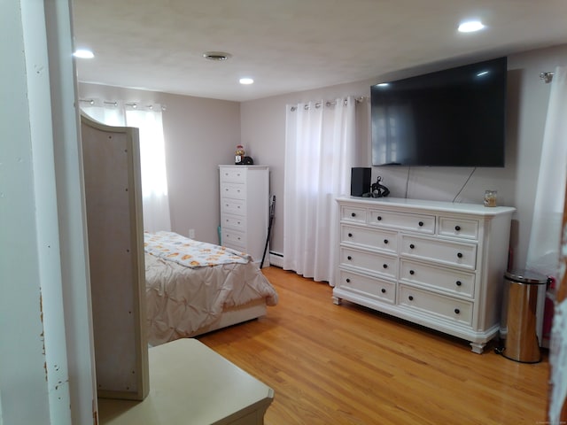 bedroom featuring a baseboard radiator and light hardwood / wood-style flooring