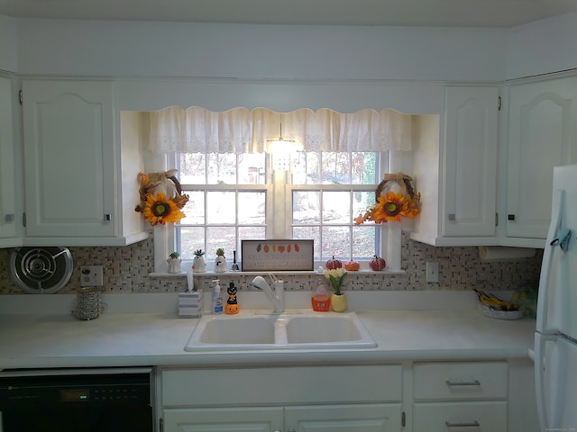 kitchen featuring black dishwasher, sink, and white cabinets