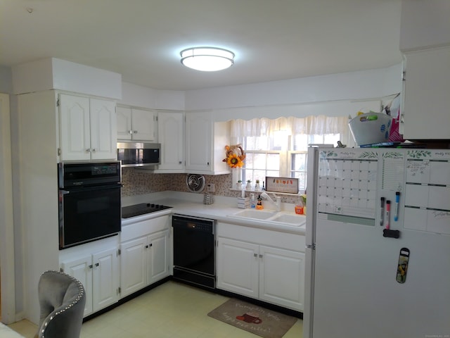 kitchen with decorative backsplash, white cabinetry, black appliances, and sink