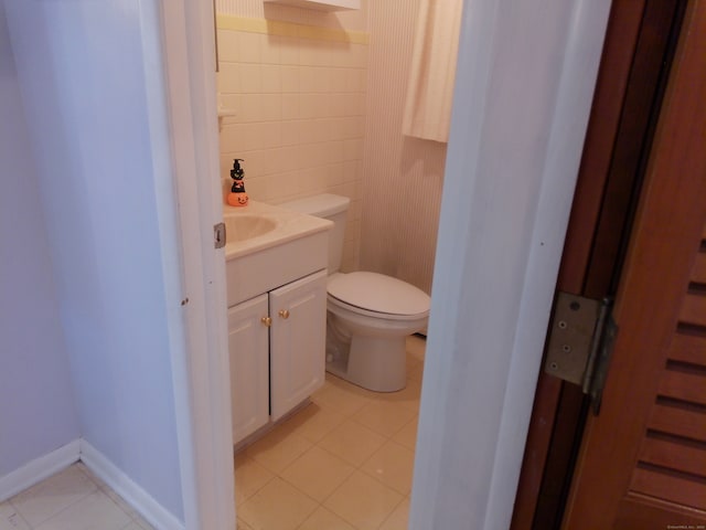 bathroom with toilet, vanity, and tile patterned floors