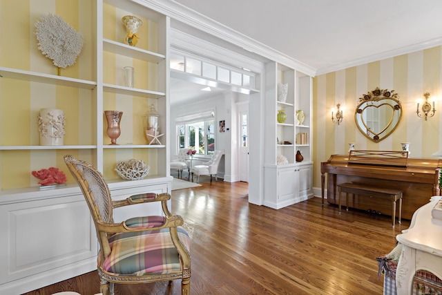 sitting room with dark hardwood / wood-style flooring, built in features, and ornamental molding