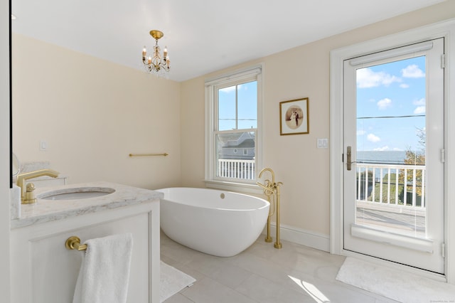 bathroom with vanity, a tub to relax in, tile patterned floors, and an inviting chandelier