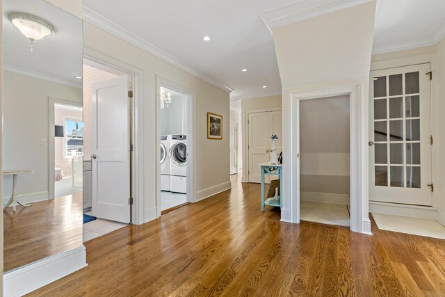 interior space with ornamental molding, separate washer and dryer, and light hardwood / wood-style floors