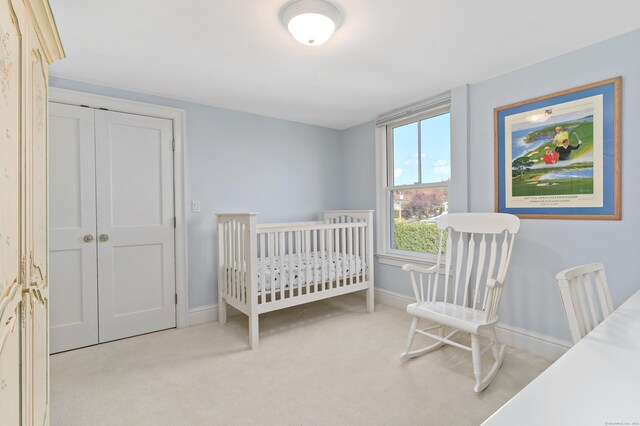 bedroom featuring light carpet and a closet