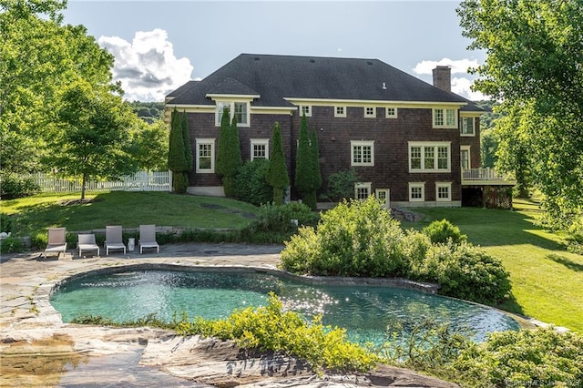 rear view of house featuring a patio and a yard