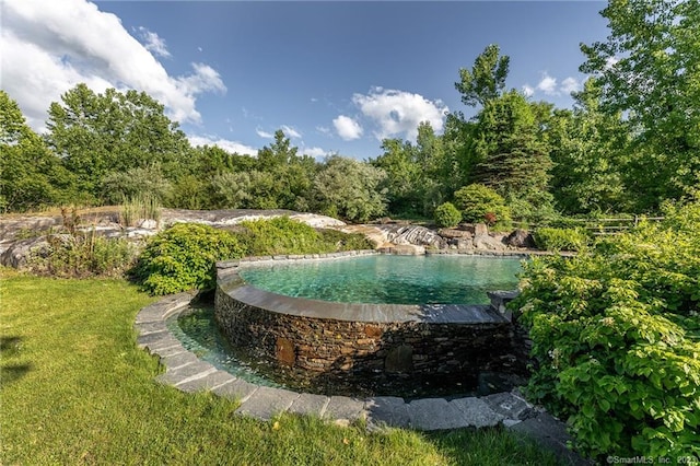 view of property's community featuring a lawn and a pool