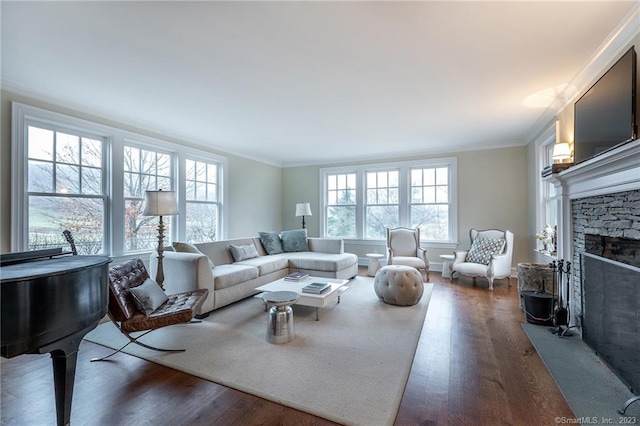 living room featuring a wealth of natural light, ornamental molding, a fireplace, and dark hardwood / wood-style flooring