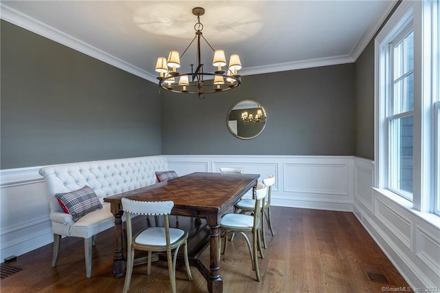 dining area featuring a chandelier, crown molding, and dark hardwood / wood-style flooring