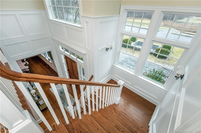 stairs featuring a wealth of natural light and hardwood / wood-style flooring