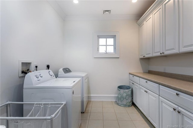 laundry room featuring light tile patterned floors, ornamental molding, cabinets, and separate washer and dryer