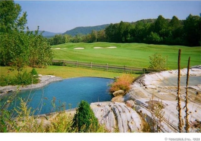 view of property's community with a swimming pool, a yard, and a water view