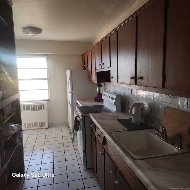 kitchen with decorative backsplash, range with electric stovetop, sink, light tile patterned floors, and radiator heating unit