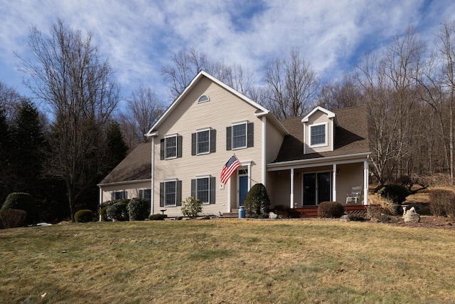 traditional-style house featuring covered porch, roof with shingles, and a front lawn