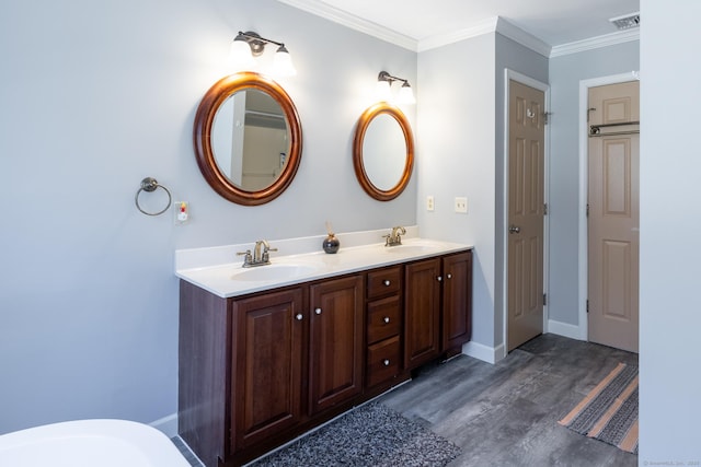 bathroom featuring double vanity, ornamental molding, visible vents, and a sink