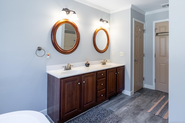 bathroom with double vanity, a sink, ornamental molding, and visible vents