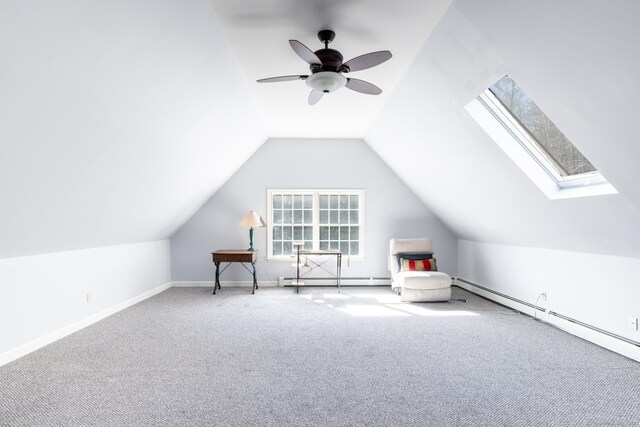 additional living space with a baseboard radiator, baseboard heating, baseboards, lofted ceiling with skylight, and carpet