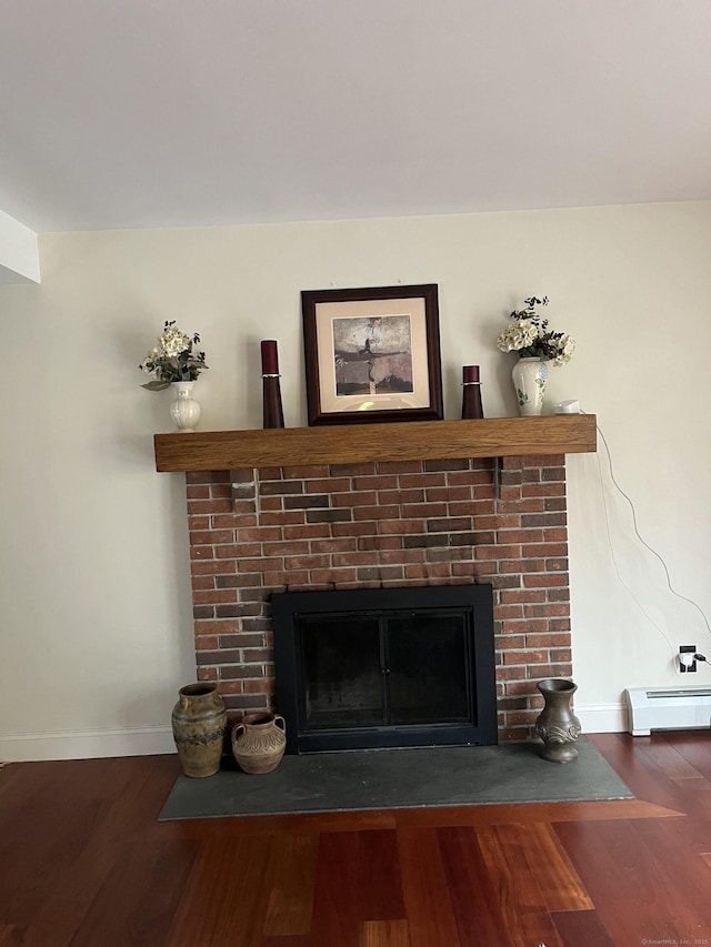 room details featuring a brick fireplace, wood finished floors, baseboards, and baseboard heating