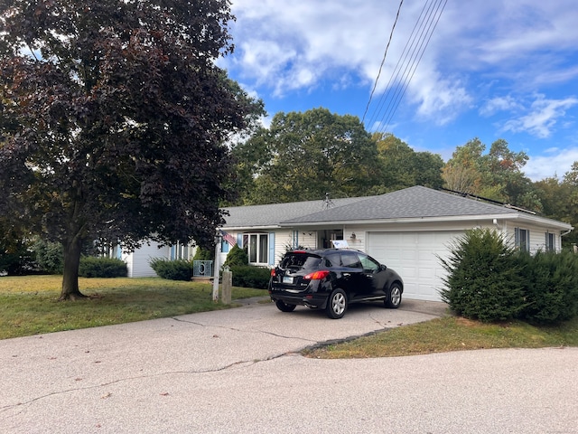 view of front of home with a front yard and a garage