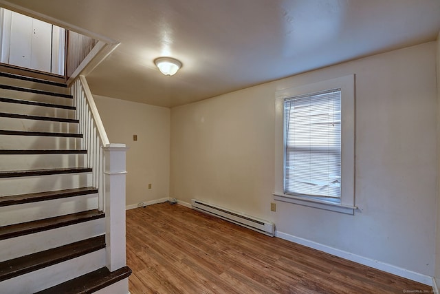 basement featuring baseboard heating and wood-type flooring