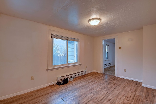 unfurnished room with a baseboard radiator, a textured ceiling, and light hardwood / wood-style flooring