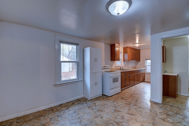 kitchen featuring white electric range oven, sink, and plenty of natural light