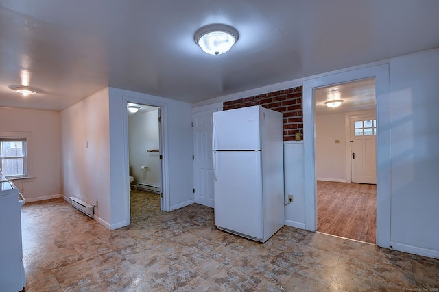 interior space featuring baseboard heating, white cabinetry, white fridge, and light hardwood / wood-style floors