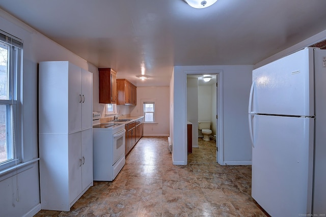 kitchen with white appliances, a healthy amount of sunlight, and sink