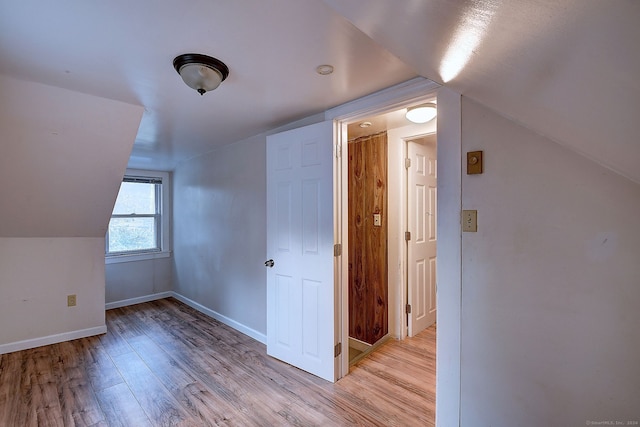 additional living space featuring light hardwood / wood-style flooring and vaulted ceiling