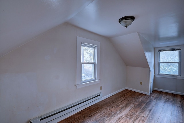 additional living space with wood-type flooring, lofted ceiling, and a baseboard radiator