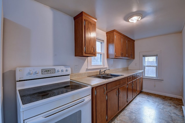 kitchen with white electric range, sink, and a wealth of natural light