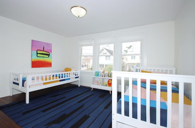 bedroom with hardwood / wood-style floors and multiple windows